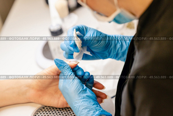 Aesthetician doing the manicure, filing the nails with a file to his client in a beauty center. Business and beauty concepts. Aesthetician doing the manicure, filing the nails with a file to his client in a beauty center. Стоковое фото, агентство Ingram Publishing / Фотобанк Лори