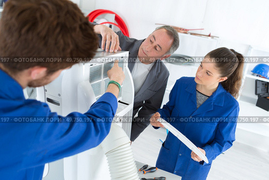 air conditioning apprentices working on a compressor. Стоковое фото, агентство Ingram Publishing / Фотобанк Лори