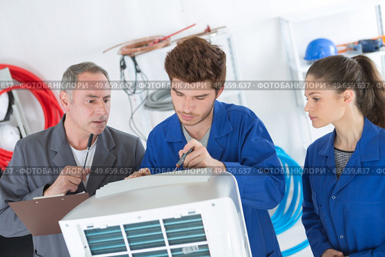 air conditioning repairmen discussing the problem with a compressor unit. Стоковое фото, агентство Ingram Publishing / Фотобанк Лори
