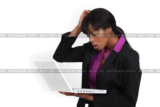 An African American businesswoman looking at her laptop with a dubious expression. Стоковое фото, агентство Ingram Publishing / Фотобанк Лори