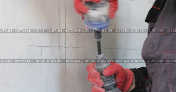 An electrician drills holes in the wall for sockets using a power tool. Close-up. Стоковое видео, видеограф Юрий Поздников / Фотобанк Лори
