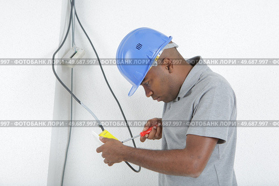an electrician wiring up switch. Стоковое фото, агентство Ingram Publishing / Фотобанк Лори