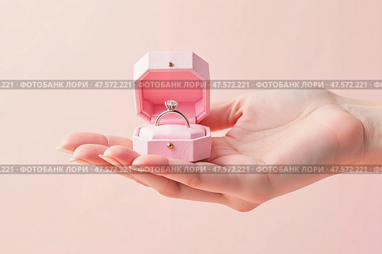 An elegant, voluminous hand holding an open box with a pink diamond ring is the epitome of a romantic marriage proposal. Стоковое AI-изображение, AI-художник ketpro.design / Фотобанк Лори