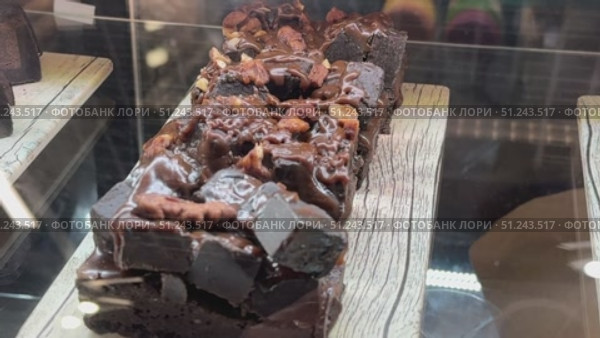 An indulgent slice of a rich and layered chocolate cake, featuring crunchy nuts and a creamy, delightful filling. Стоковое видео, видеограф worker / Фотобанк Лори