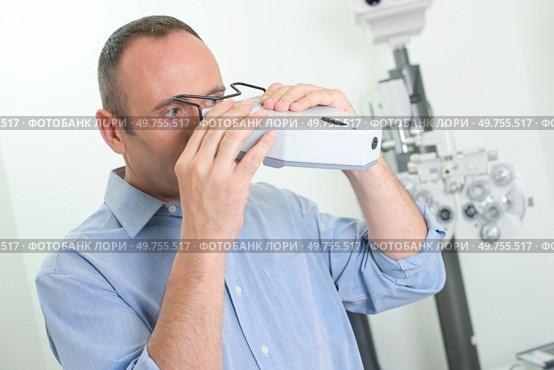 an optician checking the vision machine. Стоковое фото, агентство Ingram Publishing / Фотобанк Лори