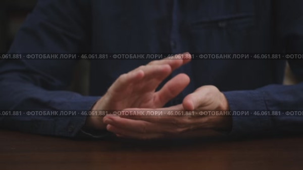 An unrecognizable businessman in a blue shirt sits at a table and claps his hands with approval. applause for a new achievement, a victory. business concept of success. close-up. Стоковое видео, видеограф ЛУНИНА ВЕРОНИКА / Фотобанк Лори