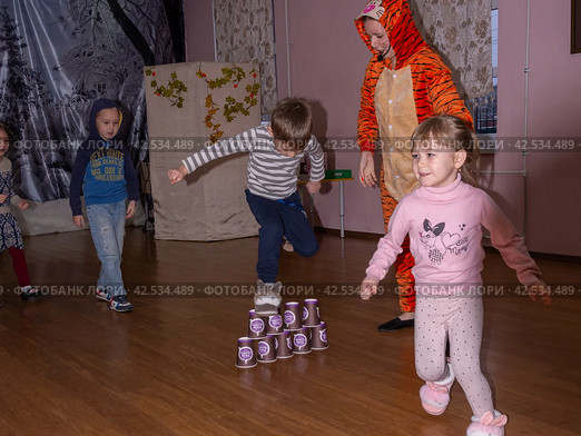 Аниматор играет с детьми из многодетных семей на праздничном мероприятии, организованном благотворительной организацией. The animator plays with children from large families at a festive event organized by a charity organization. (2021 год) Редакционное фото, фотограф Мария / Фотобанк Лори