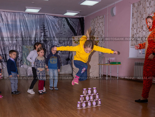 Аниматор играет с детьми из многодетных семей на праздничном мероприятии, организованном благотворительной организацией. The animator plays with children from large families at a festive event organized by a charity organization. (2021 год) Редакционное фото, фотограф Мария / Фотобанк Лори