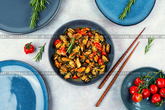 Appetizing fried mussels in vegetable sauce. Healthy seafood and chopstick. Flat lay.. Cooked tasty mussels. Стоковое фото, агентство Ingram Publishing / Фотобанк Лори