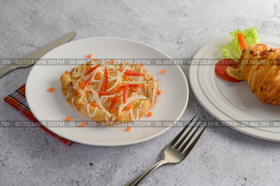 Appetizing of Almond twist bread placed in white dish decoration with sliced onion and carrot beautifully, fork and knife on floor, copy space. Стоковое фото, агентство Ingram Publishing / Фотобанк Лори
