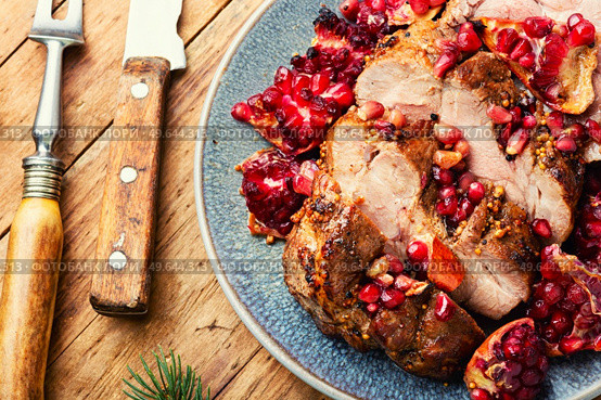 Appetizing piece of pork loin in a fruity marinade. Fried meat with pomegranate.. Pork loin in pomegranate marinade. Стоковое фото, агентство Ingram Publishing / Фотобанк Лори