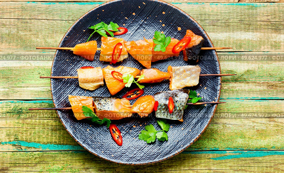 Appetizing pieces of dried salted salmon on wooden skewers. Dried fish salmon. Стоковое фото, агентство Ingram Publishing / Фотобанк Лори