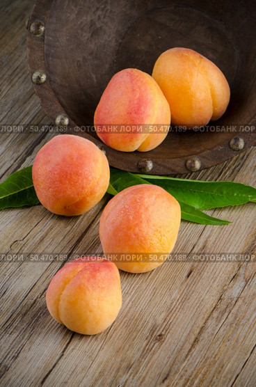 Apricots with leaves on the wooden table. Стоковое фото, агентство Ingram Publishing / Фотобанк Лори