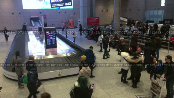 Arrived passengers are expected luggage in baggage delivery area. Arrival lounge of the Pulkovo International airport. It serves citizens of St. Petersburg (2019 год). Редакционное видео, видеограф Кекяляйнен Андрей / Фотобанк Лори