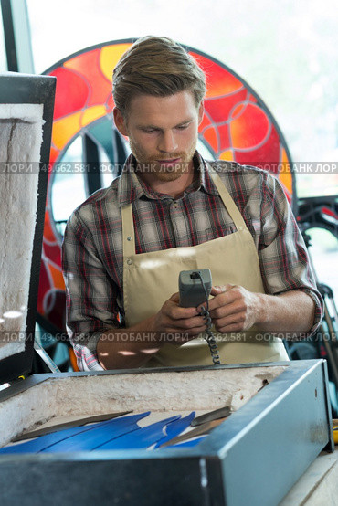 artisan operating machinery in studio. Стоковое фото, агентство Ingram Publishing / Фотобанк Лори