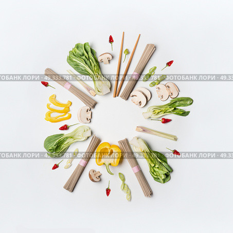 Asian food creative layout round frame on white desk background, top view. Asian cuisine ingredients with soba noodles, vegetables, spices and pak choi. Vegetarian eating and healthy nutrition concept. Стоковое фото, агентство Ingram Publishing / Фотобанк Лори