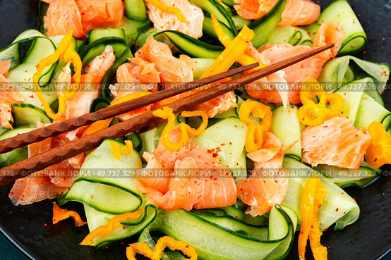 Asian spicy salad with salted salmon and fresh cucumbers and chopstick. Low carbohydrate breakfast.. Fish salad with cucumber, macro. Стоковое фото, агентство Ingram Publishing / Фотобанк Лори
