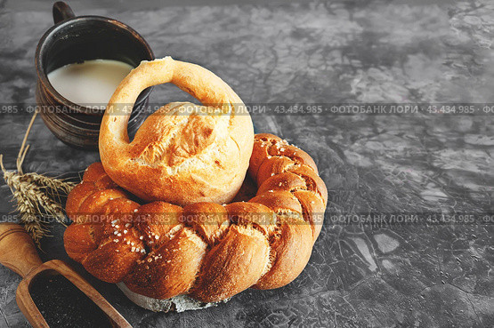 Assortment of white bread. Kalach and challah made of wheat flour on table with milk. Copy space. Стоковое фото, фотограф Оксана Медведева / Фотобанк Лори