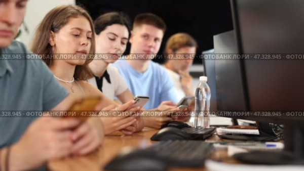 At computer class, young girl student sits with mobile phone and listens admiringly to teacher. Стоковое видео, видеограф Яков Филимонов / Фотобанк Лори
