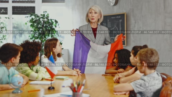 at evening geography lesson, elderly teacher tells attentive students about France. Стоковое видео, видеограф Яков Филимонов / Фотобанк Лори
