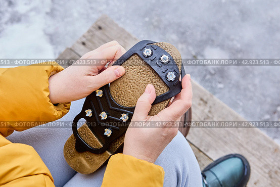 Attaching rubber pad with spikes to sole of shoe will prevent slipping during icy conditions. Стоковое фото, фотограф Владимир Григорьев / Фотобанк Лори