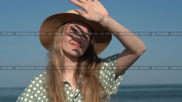 Authentic young woman in straw hat and light green polka dot dress on background of sea waves. Стоковое видео, видеограф А. А. Пирагис / Фотобанк Лори