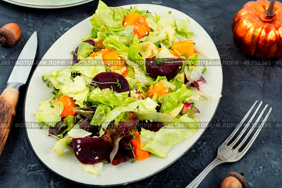 Autumn salad of baked pumpkin, beetroot and greens in a plate on the table. Healthy eating. Autumn salad with pumpkin and beets. Стоковое фото, агентство Ingram Publishing / Фотобанк Лори