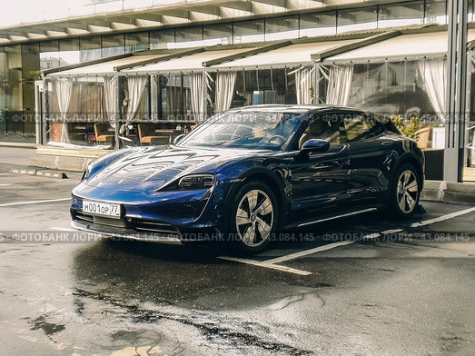 Автомобиль Porsche Taycan синего цвета стоит на парковке (2024 год). Редакционное фото, фотограф Константин Григорьев / Фотобанк Лори
