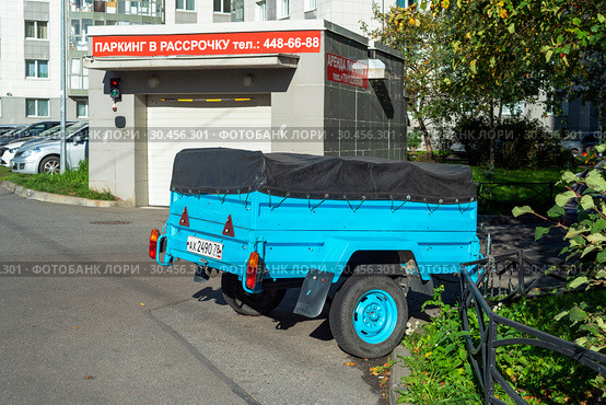 Автомобильный легковой прицеп во дворе дома. Санкт-Петербург (2018 год). Редакционное фото, фотограф Александр Щепин / Фотобанк Лори