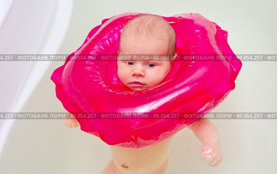 Baby bathes in a bath with a rubber ring. Стоковое фото, агентство Ingram Publishing / Фотобанк Лори