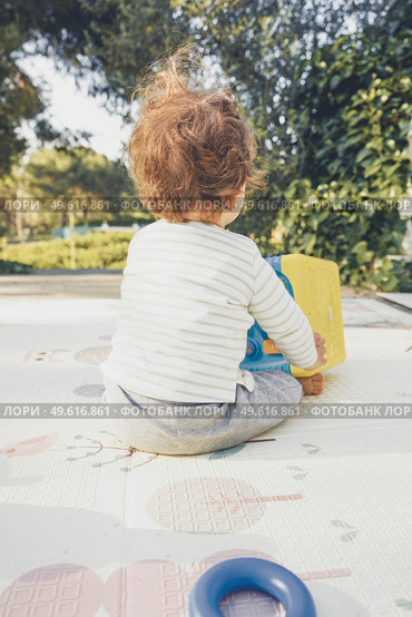 Backview of a baby playing in nature. Стоковое фото, агентство Ingram Publishing / Фотобанк Лори