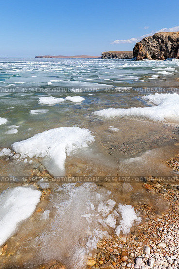 Baikal Lake in spring sunny day. Beautiful landscape with white ice floes melting on coast of Olkhon Island on shallow bay. Ice drift in Small Sea. Natural background. Change of seasons. Spring travels. Стоковое фото, фотограф Виктория Катьянова / Фотобанк Лори