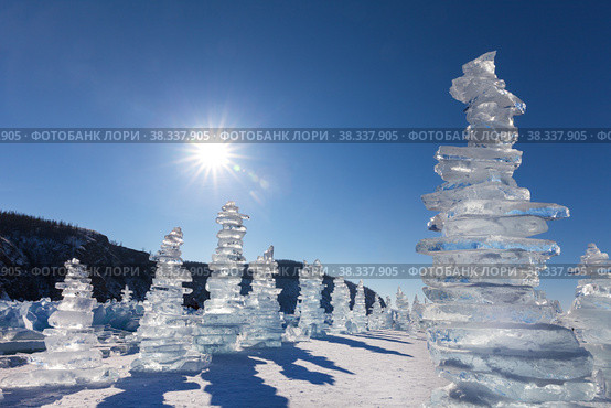Baikal Lake in winter sunny day. Tourists love to come across ice of frozen lake to famous Cape Hoboy on Olkhon Island and build pyramids from ice fragments. Winter travel, adventure and active vacation. Стоковое фото, фотограф Виктория Катьянова / Фотобанк Лори