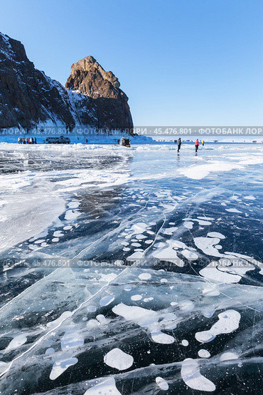 BAIKAL LAKE, OLKHON ISLAND, IRKUTSK REGION, RUSSIA - February 23, 2023:  Many tourists come to famous Cape Khoboy to walk on beautiful ice with bubbles and have picnic on sunny winter day. Редакционное фото, фотограф Виктория Катьянова / Фотобанк Лори
