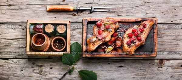 Baked meat ribs with cherry. Juicy bbq rib steak. Стоковое фото, агентство Ingram Publishing / Фотобанк Лори