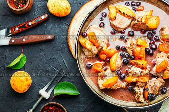 Baked pork in red wine with apricot in iron cast pan. Stew meat with apricot. Стоковое фото, агентство Ingram Publishing / Фотобанк Лори