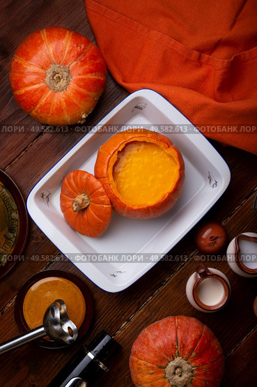 baked pumpkin cream coup served in pumpkin. served at wooden brown table with ripe orange  pumkins. flat lay. healthy life concept. Стоковое фото, агентство Ingram Publishing / Фотобанк Лори