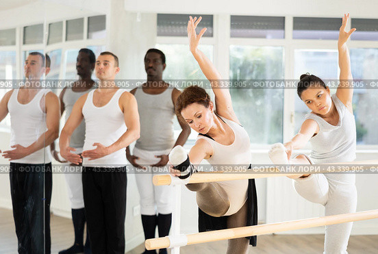 Ballet pose grand batman - ballet troupe of different nationalities at choreography lesson. Стоковое фото, фотограф Яков Филимонов / Фотобанк Лори
