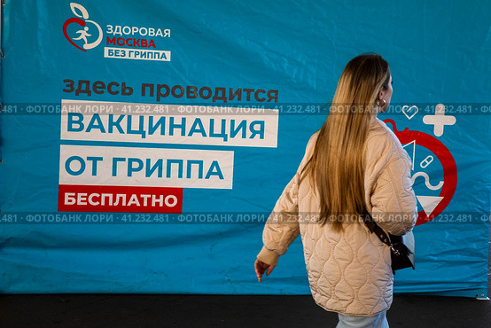 Баннер мобильного пункта бесплатной вакцинации от гриппа в специальном автомобиле скорой помощи в городе Москве, Россия (2023 год). Редакционное фото, фотограф Николай Винокуров / Фотобанк Лори