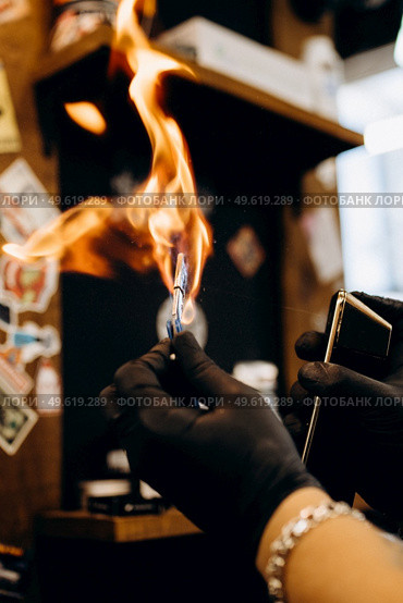 barberman burns razor with fire. Стоковое фото, агентство Ingram Publishing / Фотобанк Лори