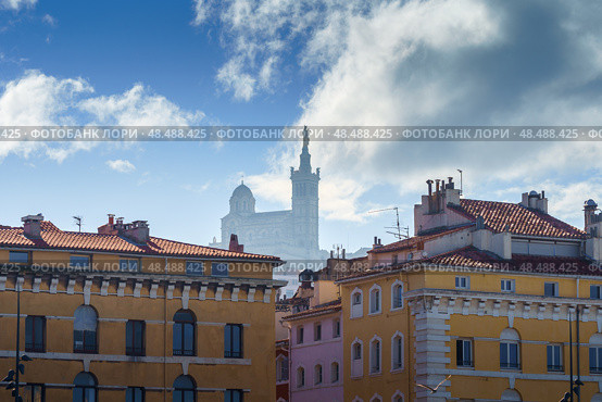 Basilique Notre-Dame de la Garde in the foggy background with red tiled roof Marseille houses (2018 год). Стоковое фото, фотограф Сергей Богомяко / Фотобанк Лори