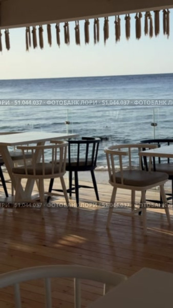 Beach cafe on sandy beach under straw umbrella, palm trees and beautiful sea on exotic tropical island. Стоковое видео, видеограф Zita Khasanova / Фотобанк Лори