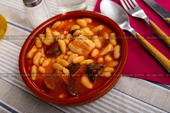 Beans stewed with pork, blood sausage and chorizo in clayware. Стоковое фото, фотограф Яков Филимонов / Фотобанк Лори