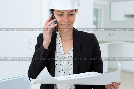 beatiful woman engineer with plans papers on building site. Стоковое фото, агентство Ingram Publishing / Фотобанк Лори