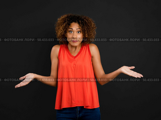 Beautiful African American woman with arms open against a black background. Стоковое фото, агентство Ingram Publishing / Фотобанк Лори