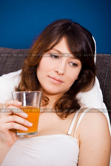 Beautiful and healthy young woman drinking a orange juice. Стоковое фото, агентство Ingram Publishing / Фотобанк Лори