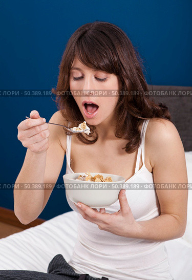 Beautiful and healthy young woman eating a cup of cereals with yogurt. Стоковое фото, агентство Ingram Publishing / Фотобанк Лори