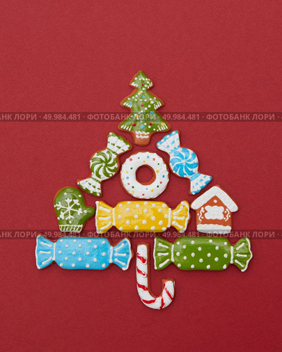 Beautiful Christmas tree made of gingerbread cookies with icing on a red background. Christmas card with cookies tree. Стоковое фото, агентство Ingram Publishing / Фотобанк Лори