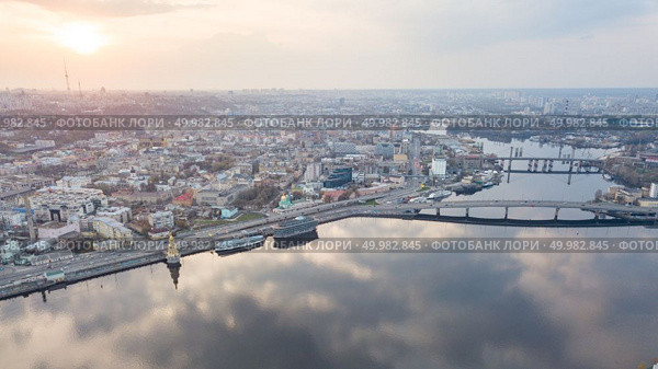 Beautiful panorama View of the Dnieper river, church of St. Nicholas on the water, River station, Havana bridge and Naberezhno-Kreschatitska street on the sunset in Kiev, Ukraine. Drone photo. Aerial top view of Dnepr river and Podol district from above, Kiev (Kyiv) city, Ukraine. Стоковое фото, агентство Ingram Publishing / Фотобанк Лори