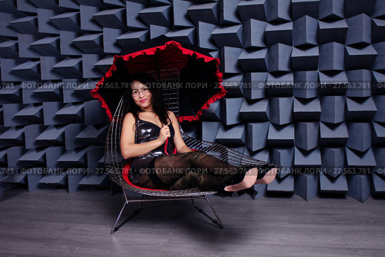 Beautiful sexy asian woman in a small black dress on a chair, modern studio image. Стоковое фото, фотограф Нелли Сабитова / Фотобанк Лори